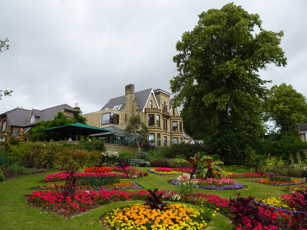 Blloming Flowers in a garden witha stone building in the background