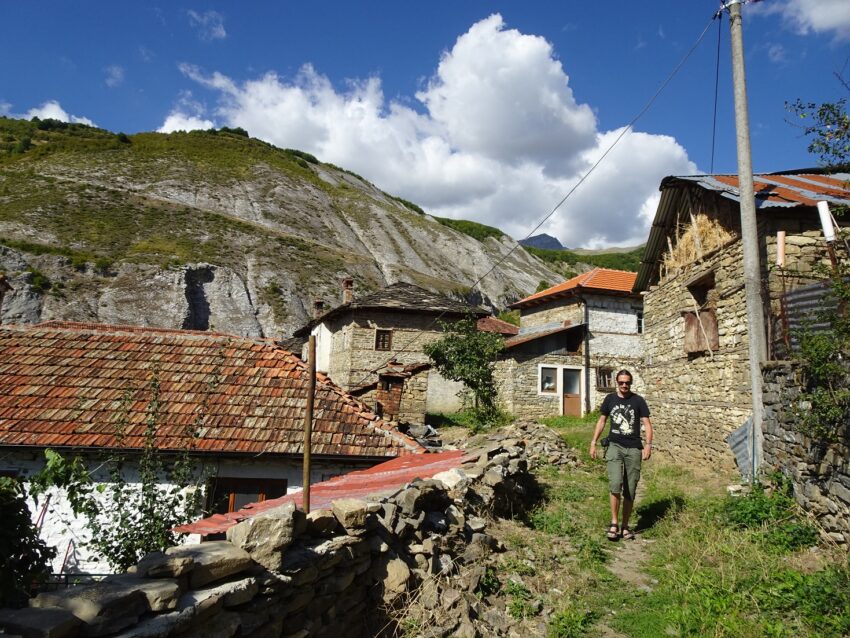 A village of traditional stone houses with a mountain in the background