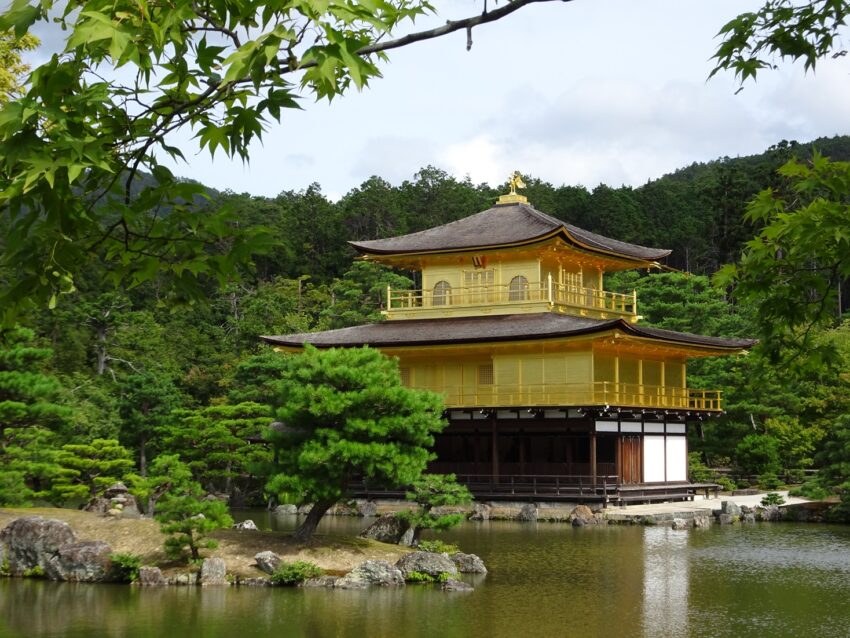 Kinkaku-ji, a golden pavilion reflected in the water of a pond and surrounded by pine trees